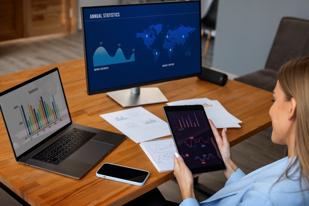 mujer sentada frente a un portátil mirando datos analíticos